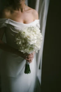 Elegant London bride holding a delicate white floral bouquet in a minimalist wedding look
