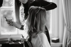 Bridal hairstylist setting a soft, effortless hairstyle with finishing spray