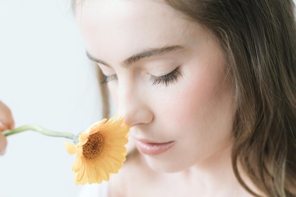 Beautiful Woman smelling an orange flower