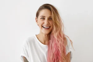Smiling woman with ombre pink semi-permanent hair dye