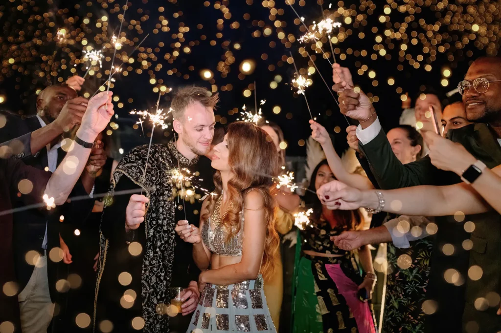 Couple’s sparkler send-off surrounded by friends and family at night