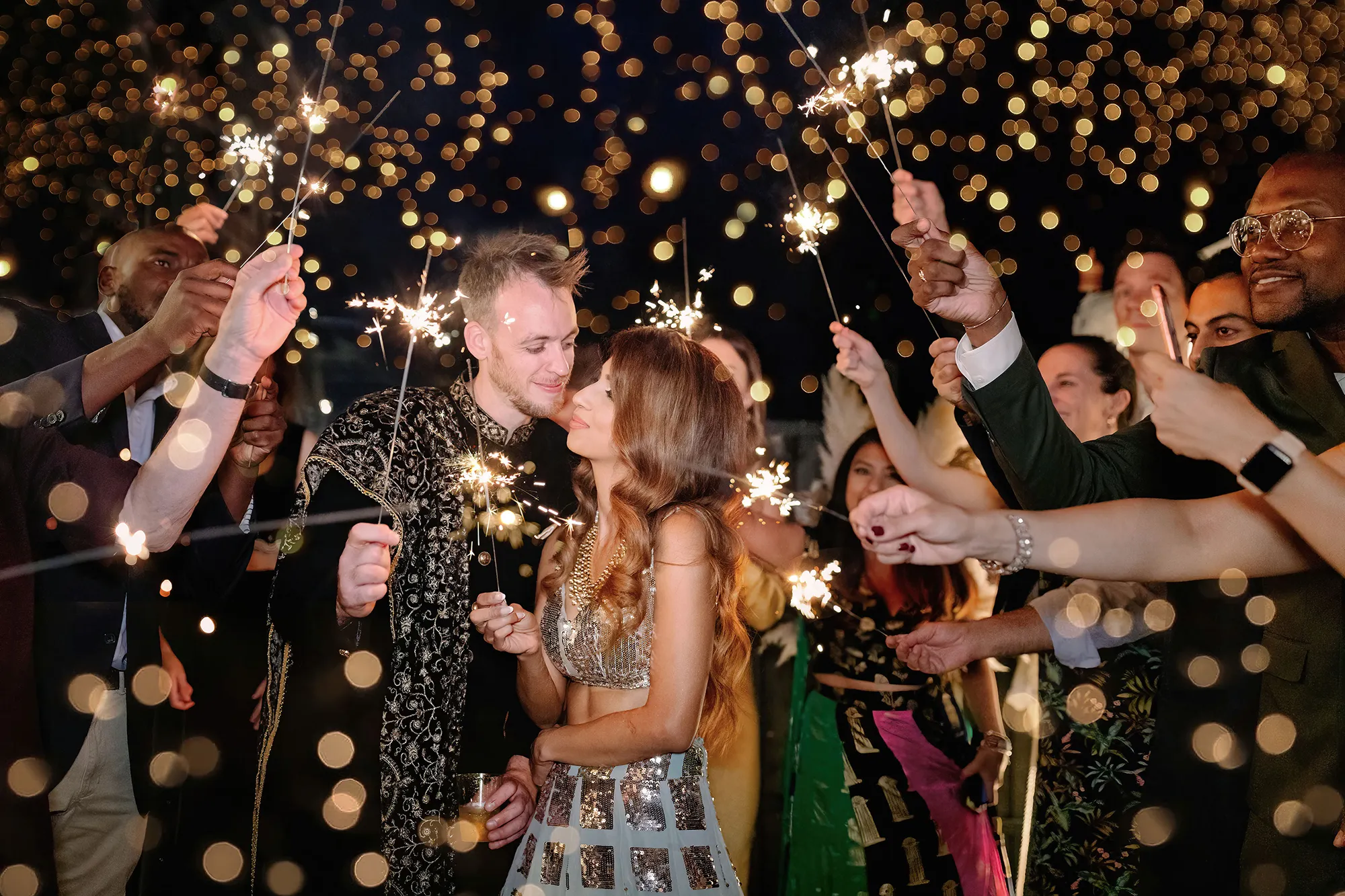 Couple’s sparkler send-off surrounded by friends and family at night