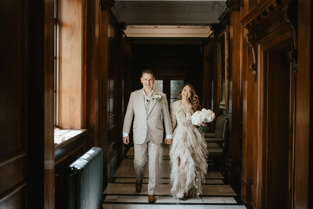 Bride Dannah and David walking hand in hand at Marylebone Town Hall.