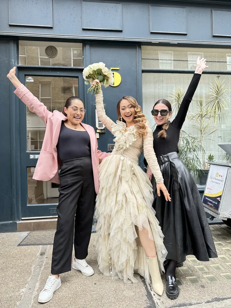 Bride Dannah in London celebrating with Izabella Bordignon and Team , holding up her bouquet.