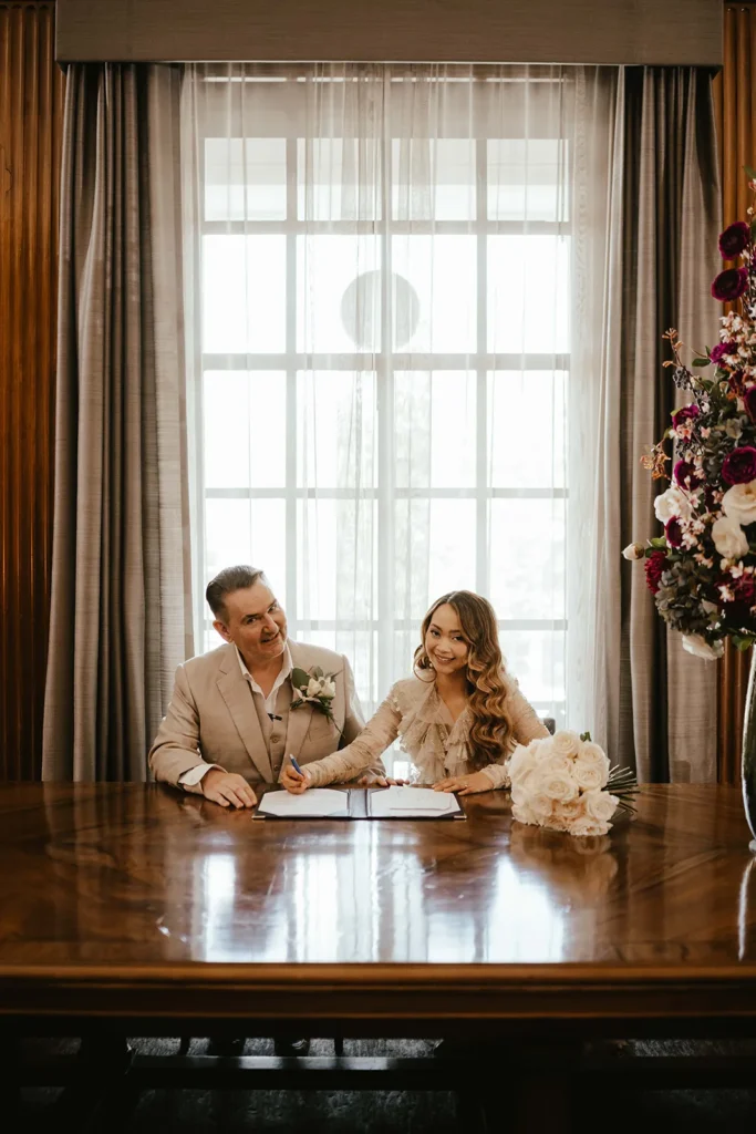 Bride Dannah and groom David signing the marriage register in a London ceremony.
