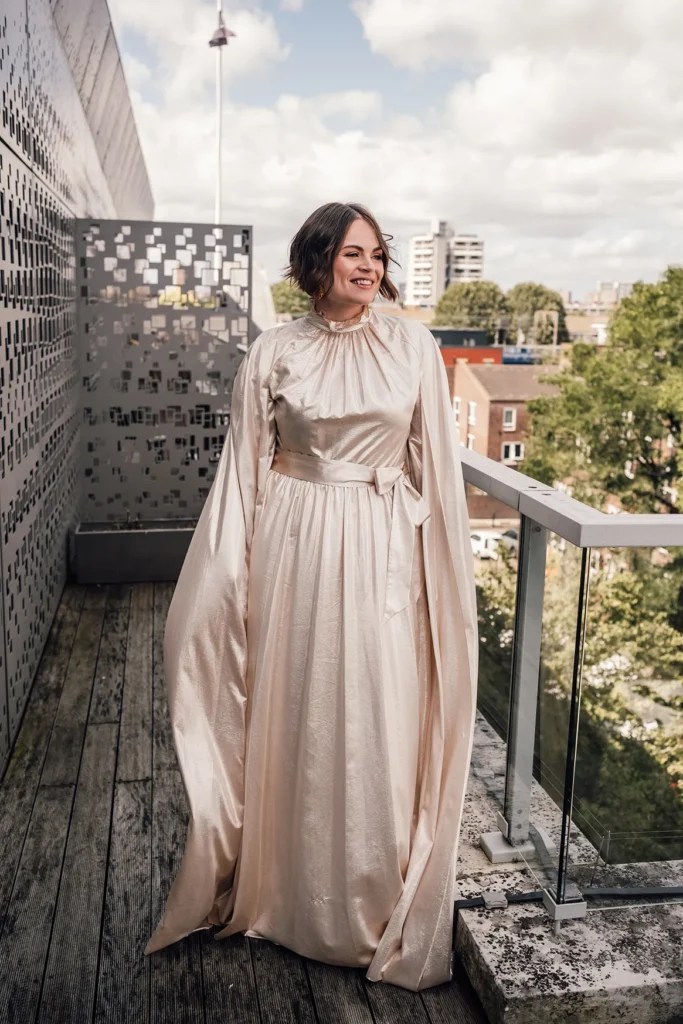 Bride Camilla smiling on a balcony in London with urban background