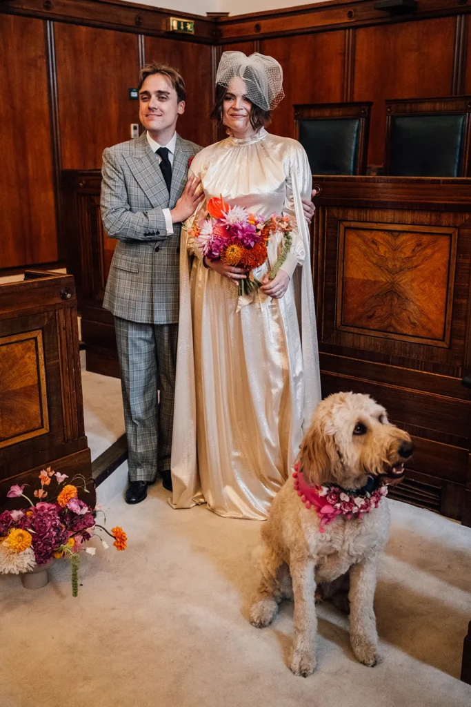 Bride Camilla with a dog wearing a floral collar at her London wedding