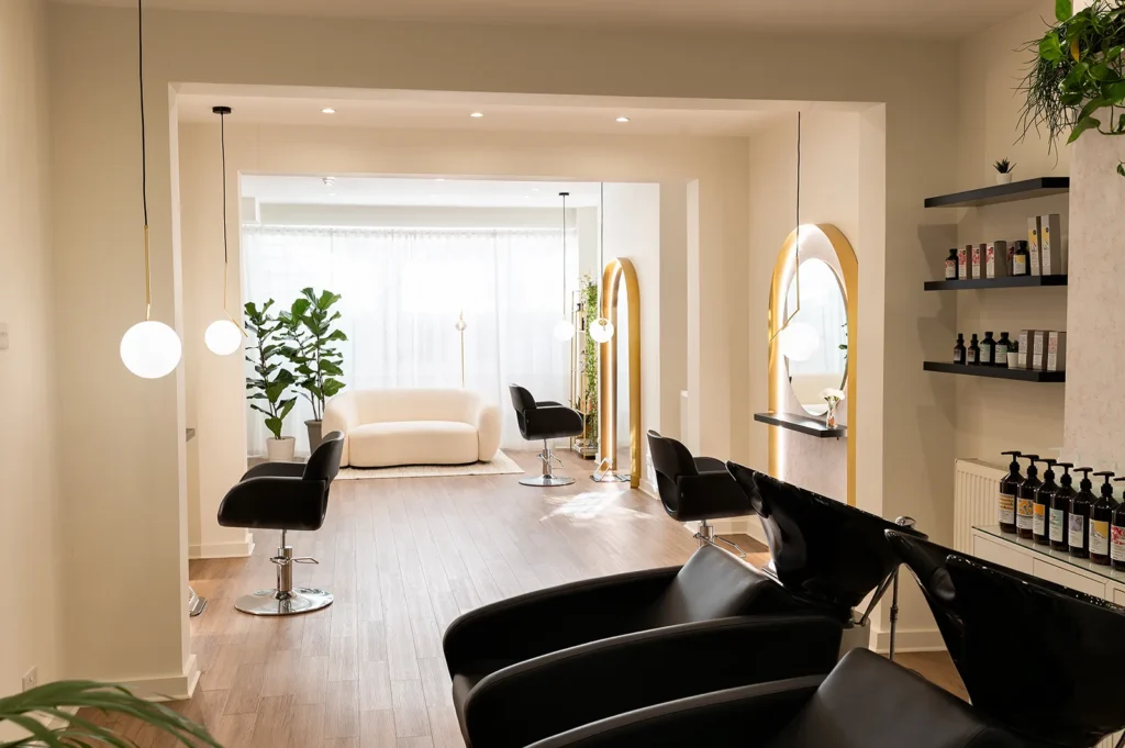 An overview of a spacious and tastefully designed hair salon in London, with multiple hairdressing stations and a minimalist aesthetic, indicative of a leading hair salon in Islington known for its expertise and ambiance.