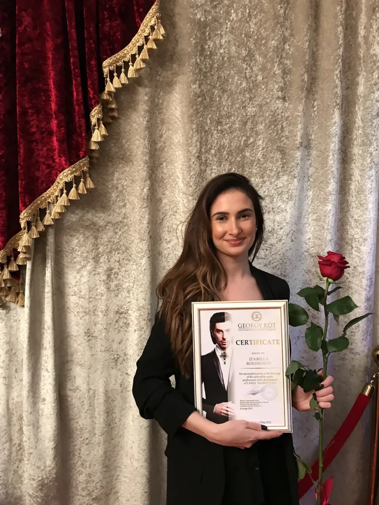 Izabella holding a certificate of achievement, symbolising the high-quality standards and professional recognition of the best hair salon in Islington.