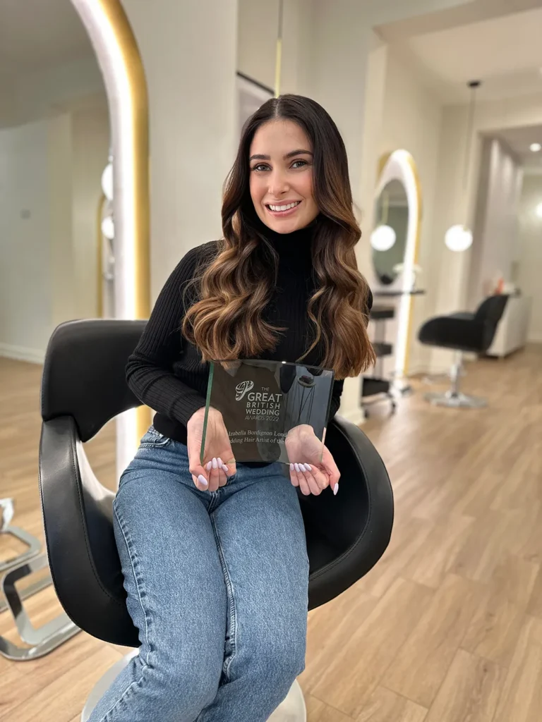 Izabella posing with a prestigious hairdressing award, highlighting the salon's acclaimed status for bridal and wedding hair styling services.