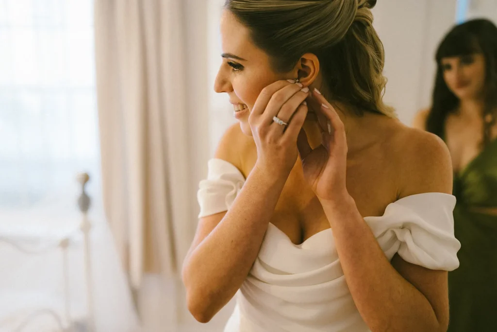 Bride putting on her earrings on her wedding day in London