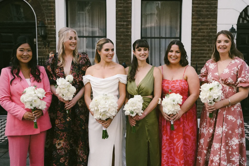 Bride with bridesmaids holding bouquets on a London street