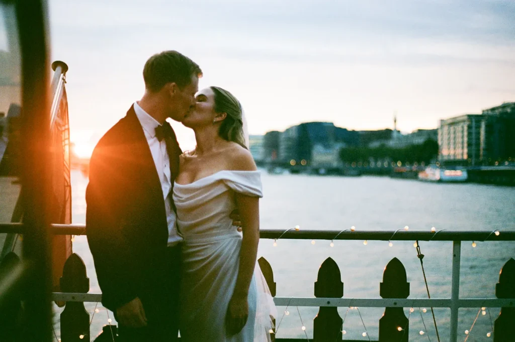 Romantic sunset kiss for bride and groom on a London boat