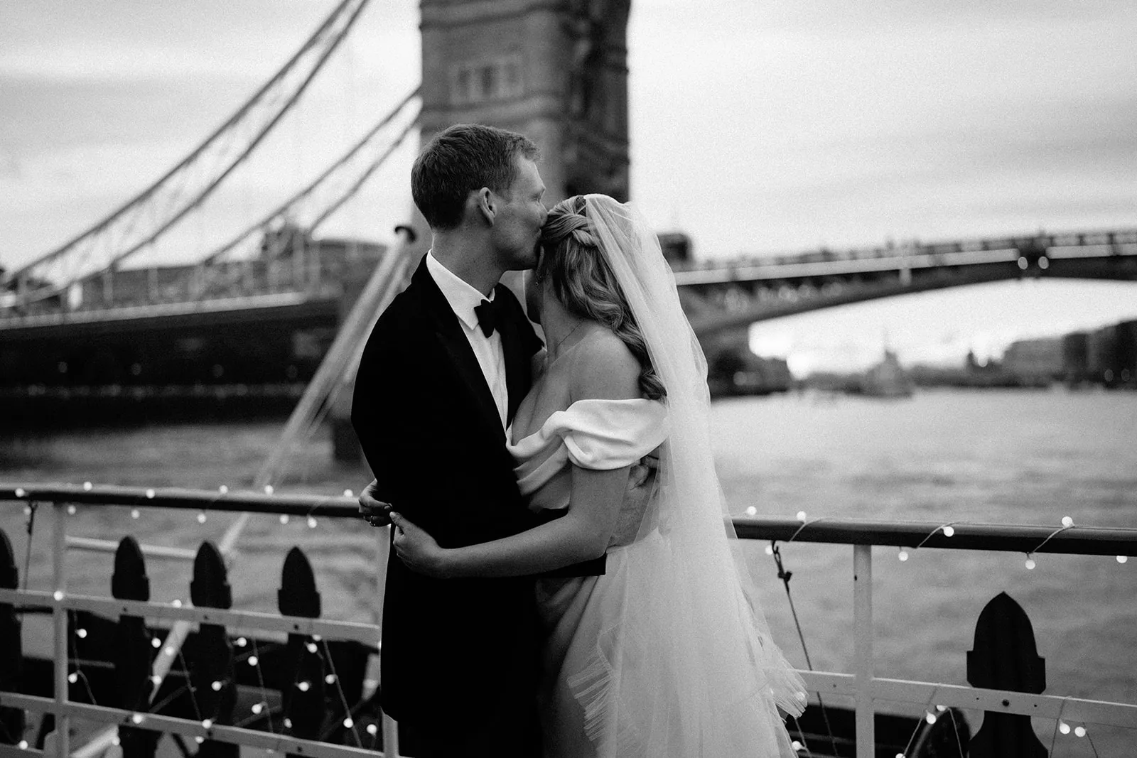Black and white romantic kiss by the Tower Bridge in London
