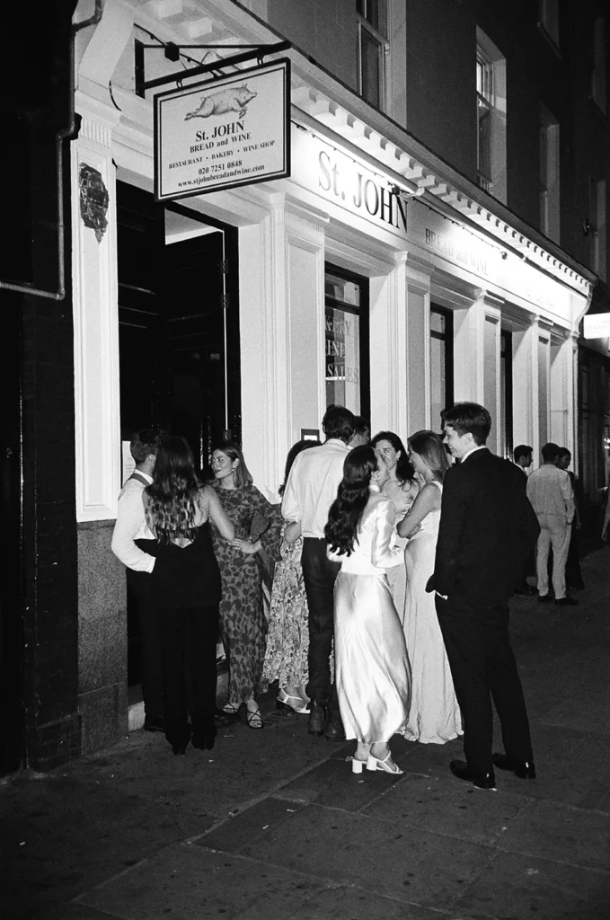 Guests mingling outside a renowned restaurant during a London wedding reception