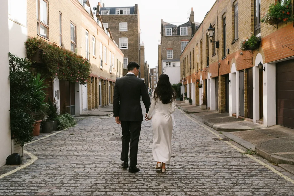 Bride and groom walking hand-in-hand down a picturesque London street