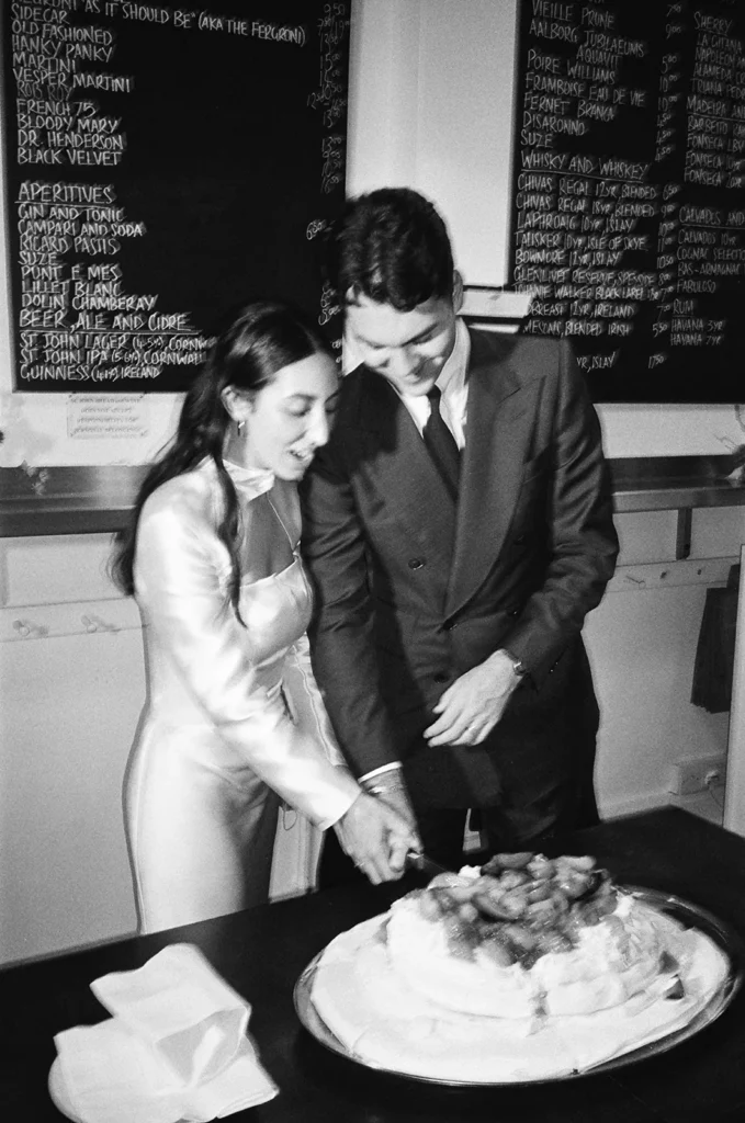 Bride and groom cutting their wedding cake at a St John Bread and Wine Restaurant in London