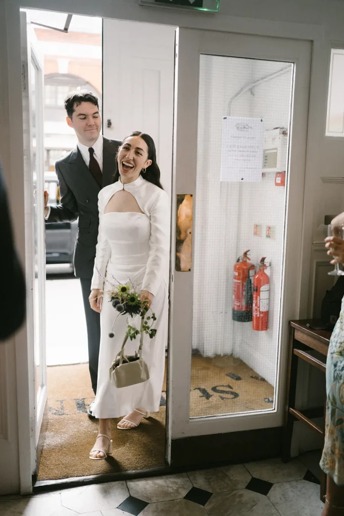 Bride and groom entering a St John Bread and Wine London restaurant, a highlight of their wedding