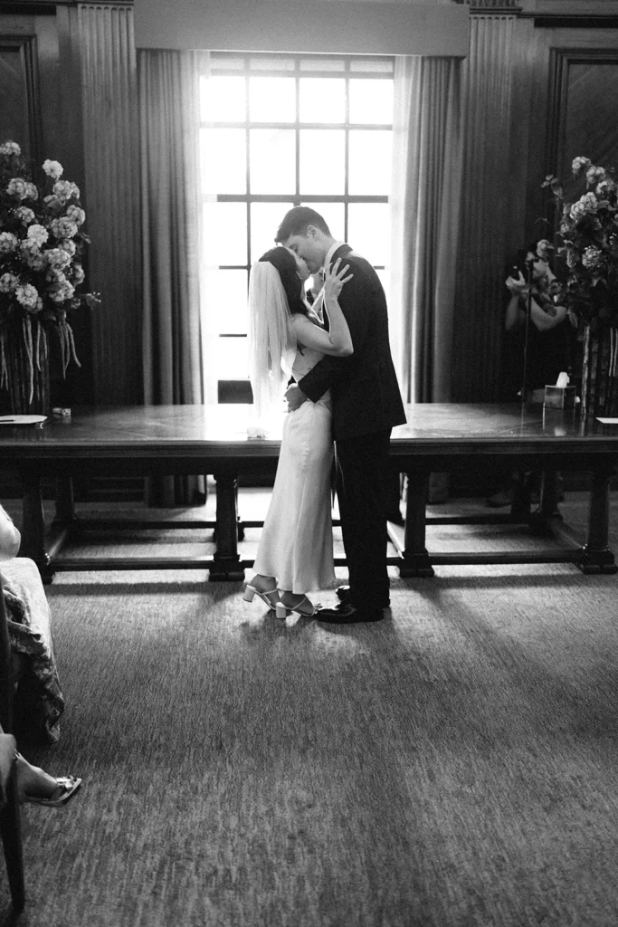 Bride and groom share a kiss at wedding ceremony at the Old Marylebone Town Hall