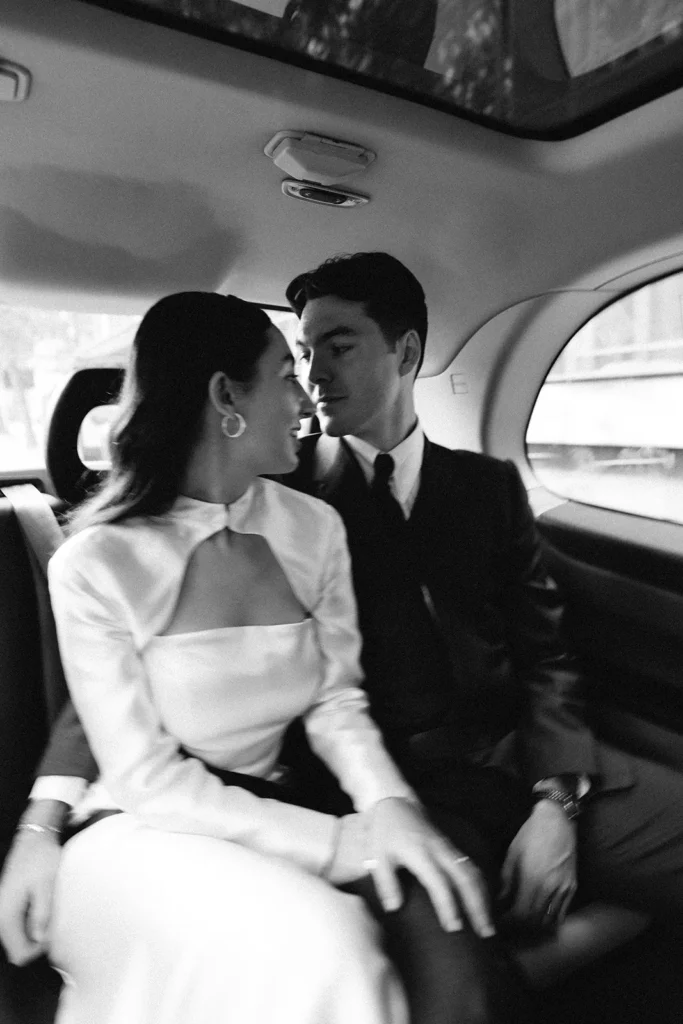 Bride and groom sharing a romantic moment in a car