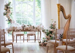 romantic wedding venue with flowers, chairs and harp and a large window