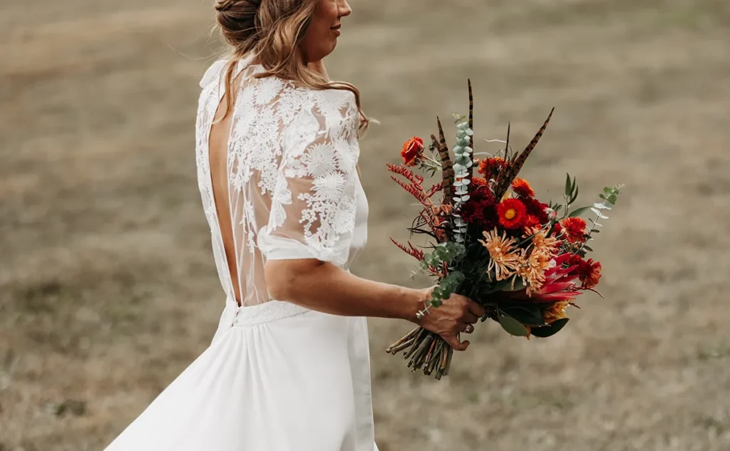 Bride holding a vibrant floral bouquet at an outdoor micro wedding