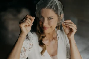 Bride adjusting her veil before boho chic wedding ceremony