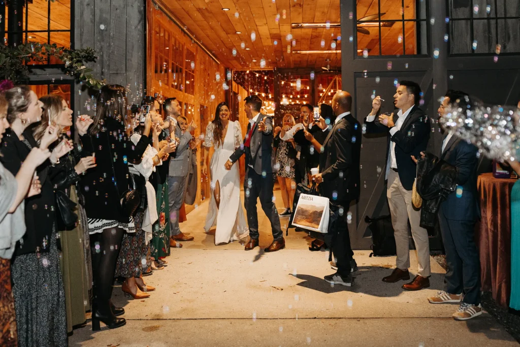 Bride and groom walking through bubble send-off with guests