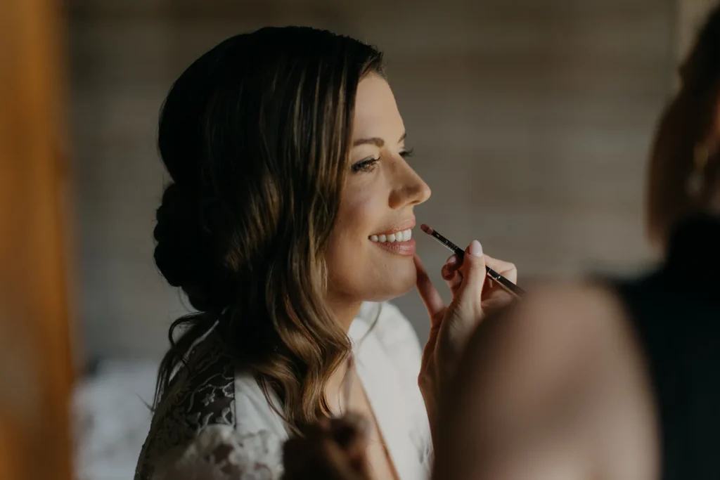 Bride getting makeup done before her boho chic wedding