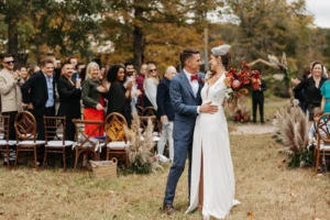 Bride and groom celebrating after wedding ceremony with guests in background