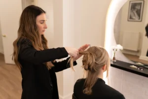 Hairstylist working on bride's hair in preparation for the bridal photoshoot