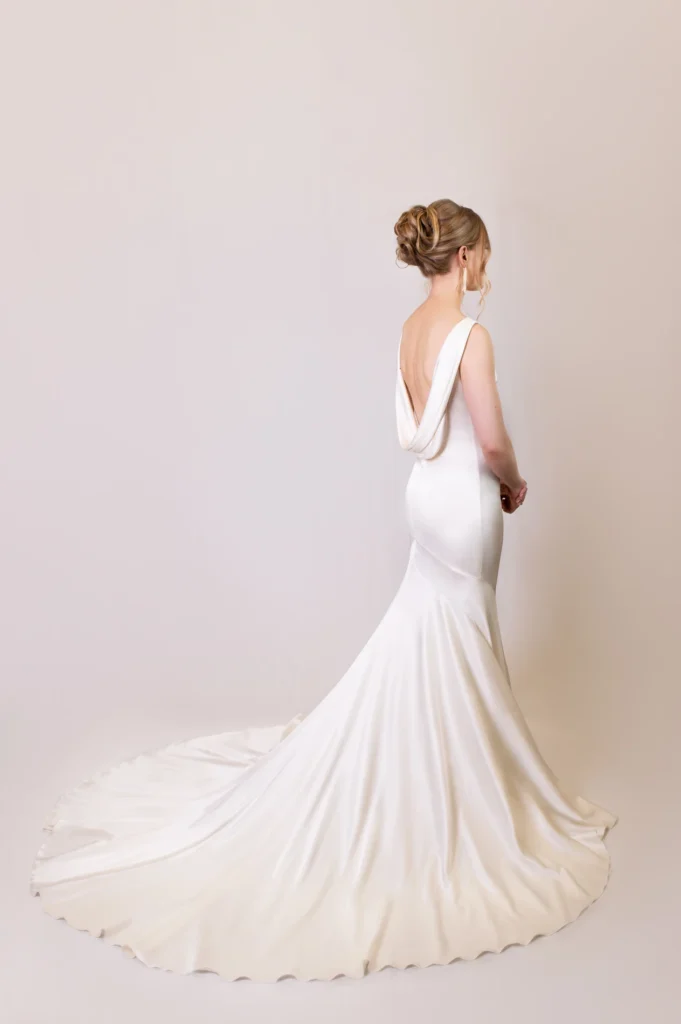 Back view of a satin bridal gown with draped back detail