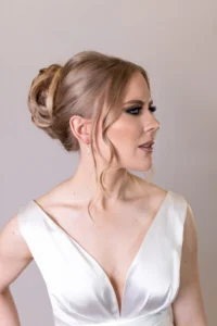 Detailed back view of a bride’s lace gown with a voluminous updo hairstyle