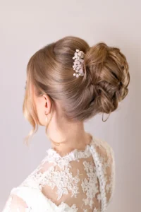 Intricate bridal updo with lace dress and hair accessory