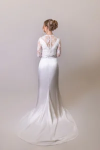 Full-length back view of satin and lace bridal gown with a long train