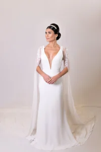 Bride wearing a wedding gown with a flowing cape and lace sleeves