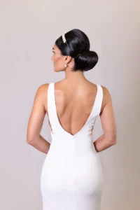 Back view of bride in a sleek updo and low-back wedding gown