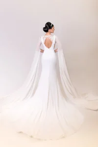 Bride holding bouquet of red tulips behind her back in a modern white gown