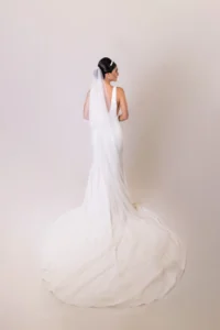 Bride in a long veil and elegant sleek low bun with a flowy train