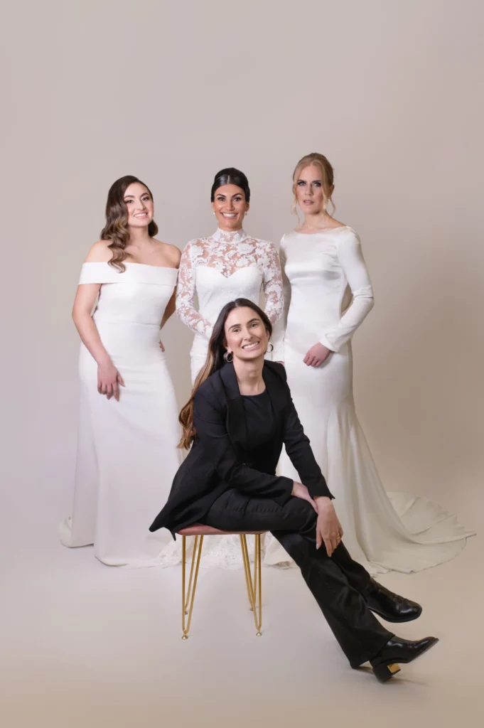 Bridal Photoshoot Featuring Three Brides in Elegant White Wedding Gowns with a Hairstylist, Showcasing Modern Bridal Hairstyles and Dresses