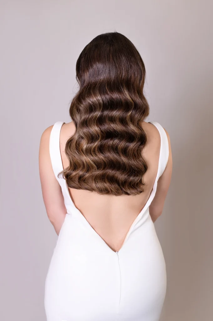 Back view of vintage waves hairstyle on bride in low-back wedding gown