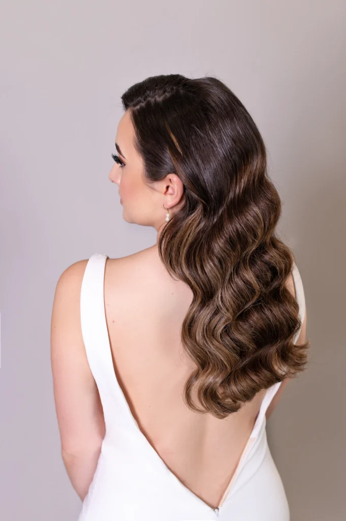 Side view of bride with vintage waves hairstyle in a sleek white gown