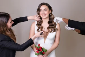 Bridal team giving final touch-ups to bride’s hair before wedding photoshoot