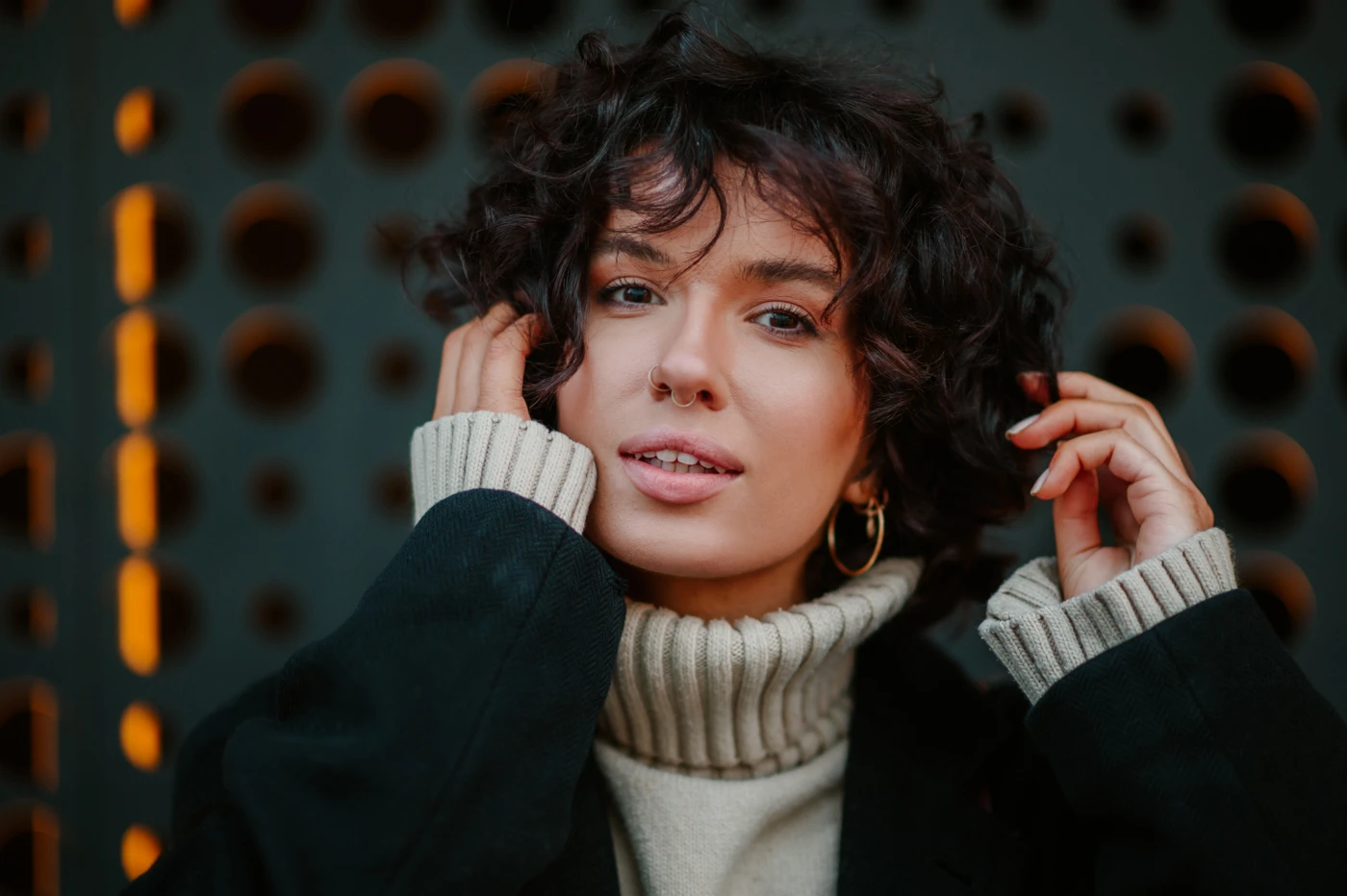 Stylish woman with short curly hair looking confident and radiant.