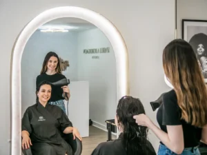 Stylist blow-drying hair for a smooth and healthy finish in a salon