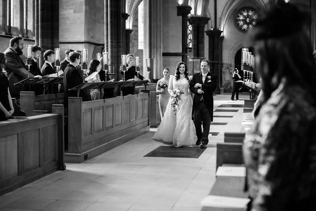 Bride walking down the aisle in a beautifully lit winter wedding ceremony.