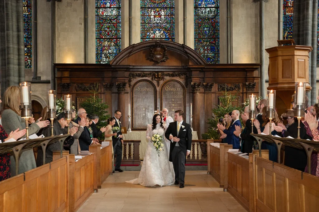 Bride and groom walking down the aisle as newlyweds in a winter wonderland setting.