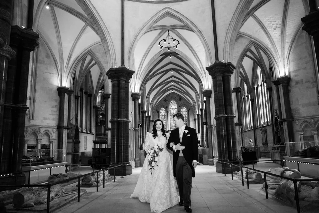 Bride and groom walking through a stunning gothic cathedral during their winter wonderland wedding.