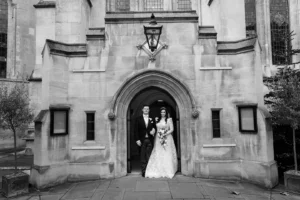 Bride and groom emerging from a historic church, radiating joy on their winter wedding day.