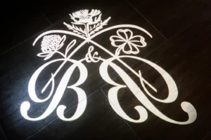 Elegant custom monogram with floral accents projected on the floor during a winter wonderland wedding.